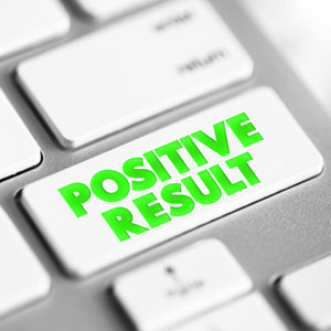 Computer keyboard with a key labeled "positive result" highlighted, symbolizing success or achievement - Escamilla Law Firm