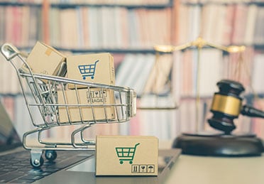 Shopping cart on table beside gavel, symbolizing product liability - Escamilla Law Firm, PLLC