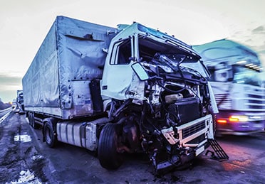 A crushed white truck on the road representing a truck accident - Escamilla Law Firm, PLLC