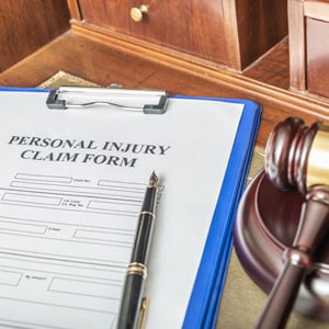 A personal injury claim form on a desk with a gavel, symbolizing legal proceedings. - Escamilla Law Firm, PLLC