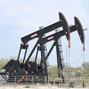 Oil pumps in a field, extracting valuable resources from the earth's depths. - Escamilla Law Firm, PLLC