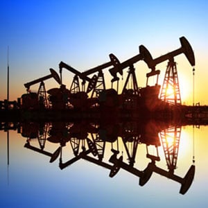 Oil pumps silhouetted against a vibrant sunset, symbolizing the energy industry's role in harnessing natural resources. - Escamilla Law Firm, PLLC