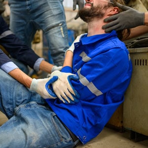 A man is restrained by others, highlighting workplace safety concerns in Texas